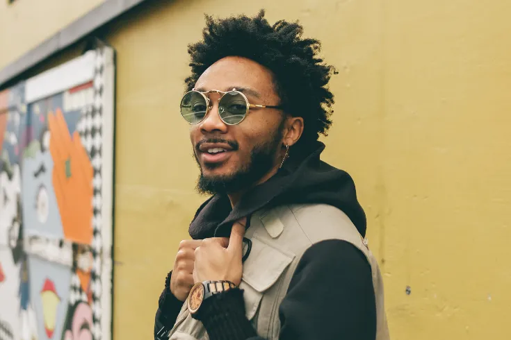 Rapaz usando óculos e com um estilo descolado.