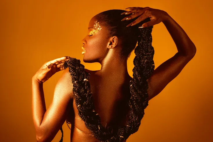 Mulher em uma pose sensual mexendo em seus longos cabelos