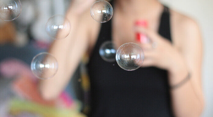 Qual o significado de usar preto no ano novo? preto no ano novo mulher de preto soprando bolhas de sabao