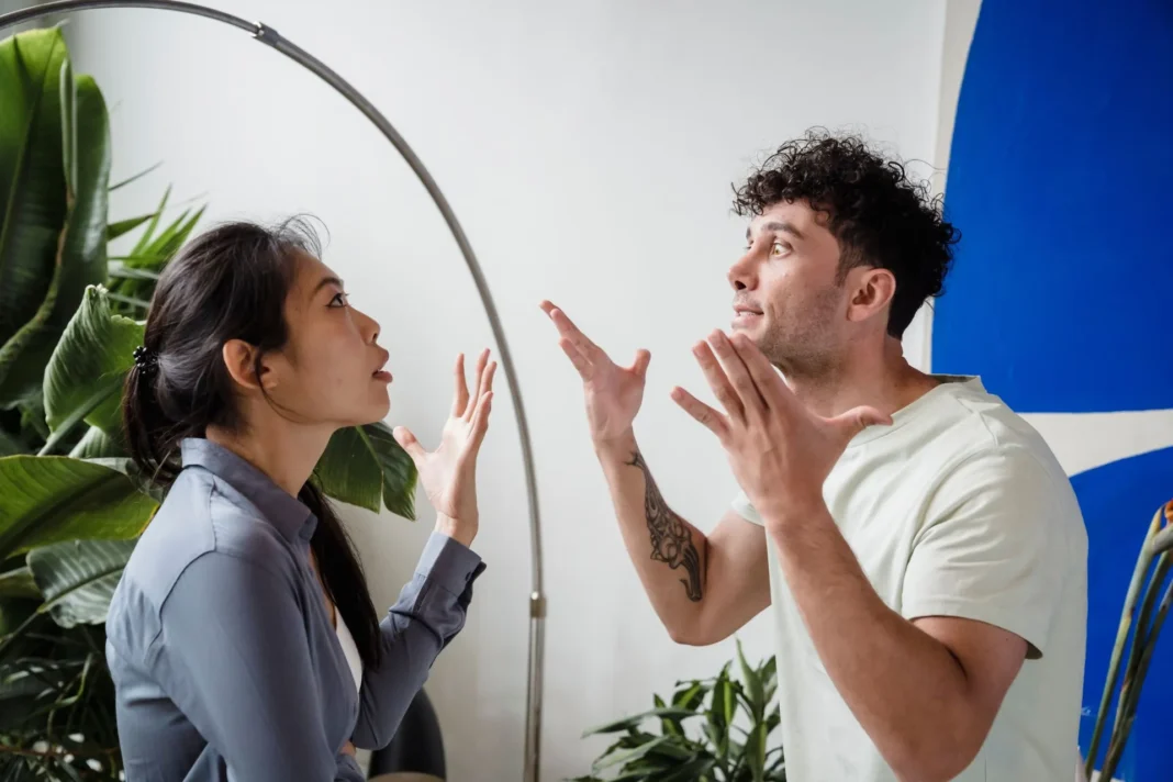Um casal discutindo acaloradamente dentro de casa.