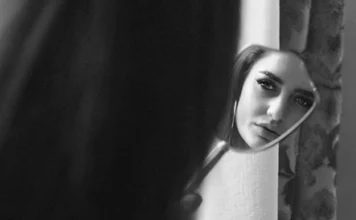 Desvendando a Sombra: como Oráculos podem iluminar aspectos inconscientes Mulher se olhando no espelho, em ambiente sombrio