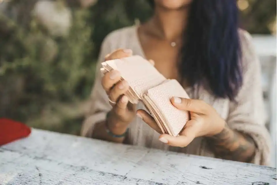 Taróloga embaralhando seu Tarot em ambiente externo.