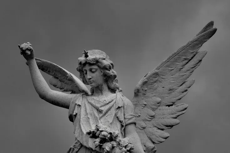 Estátua em pedra de Anjo de asas abertas, abençoando alguém