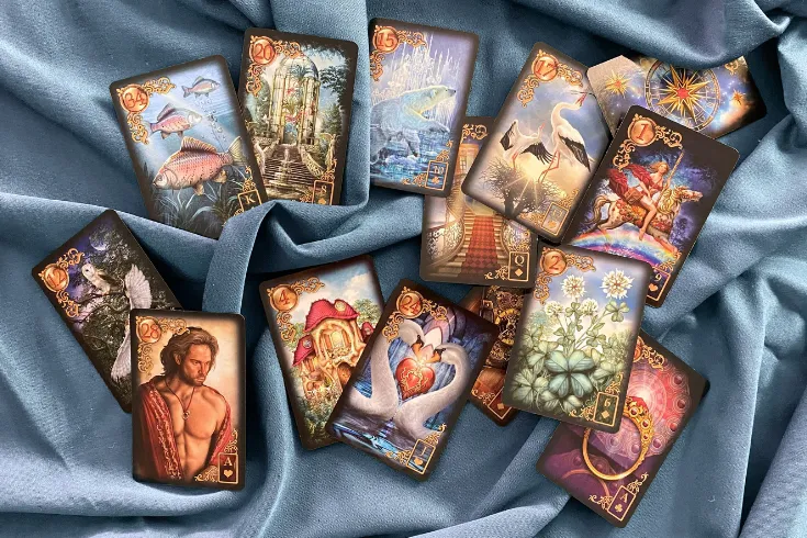 Cartas do baralho cigano, viradas para cima, sobre toalha azul