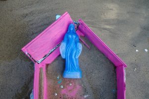 Estátua de Iemanjá na areia da praia com oratório lilás